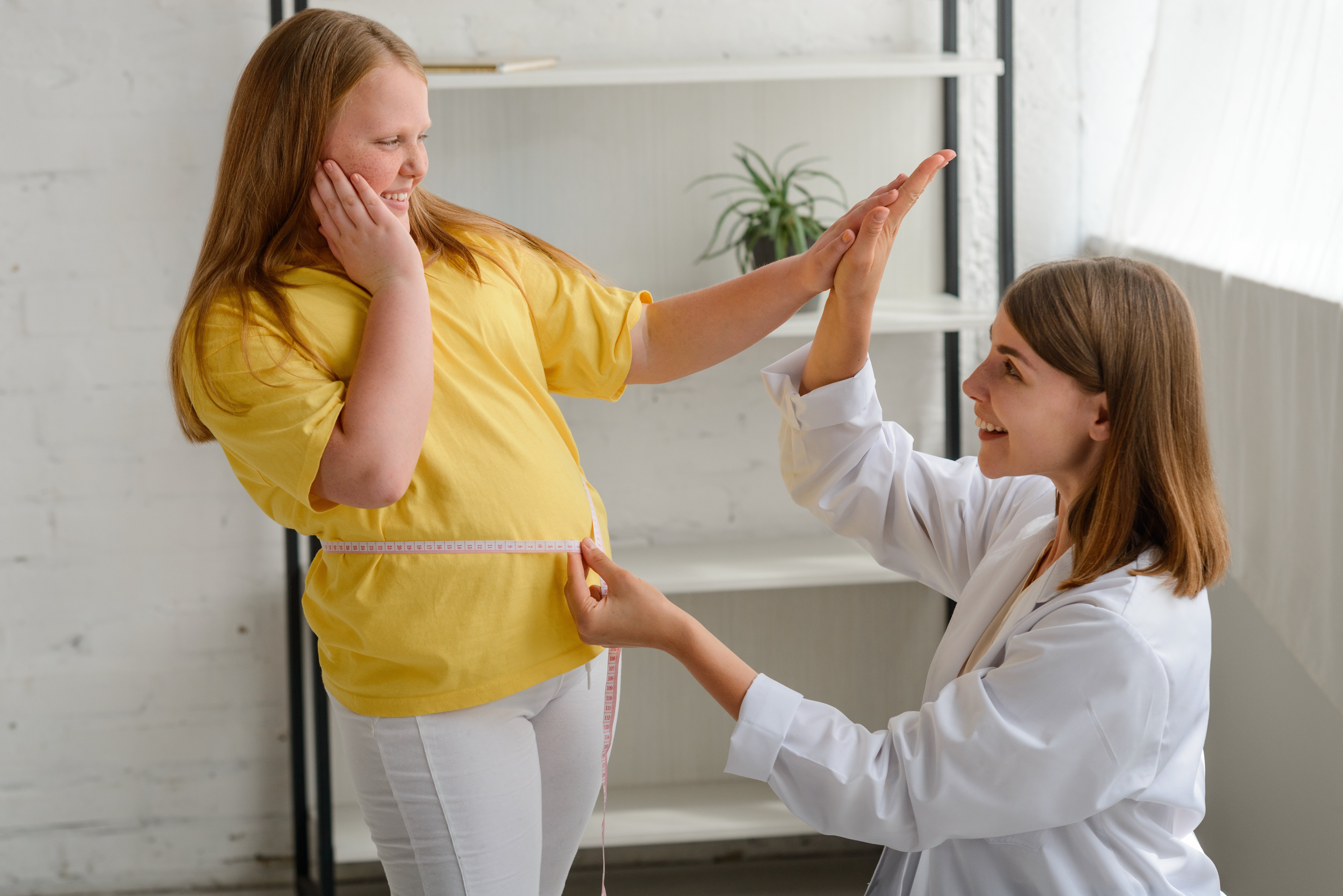 An image of a weight loss doctor measuring a patient who initially asked the question do weight loss clinics work?
