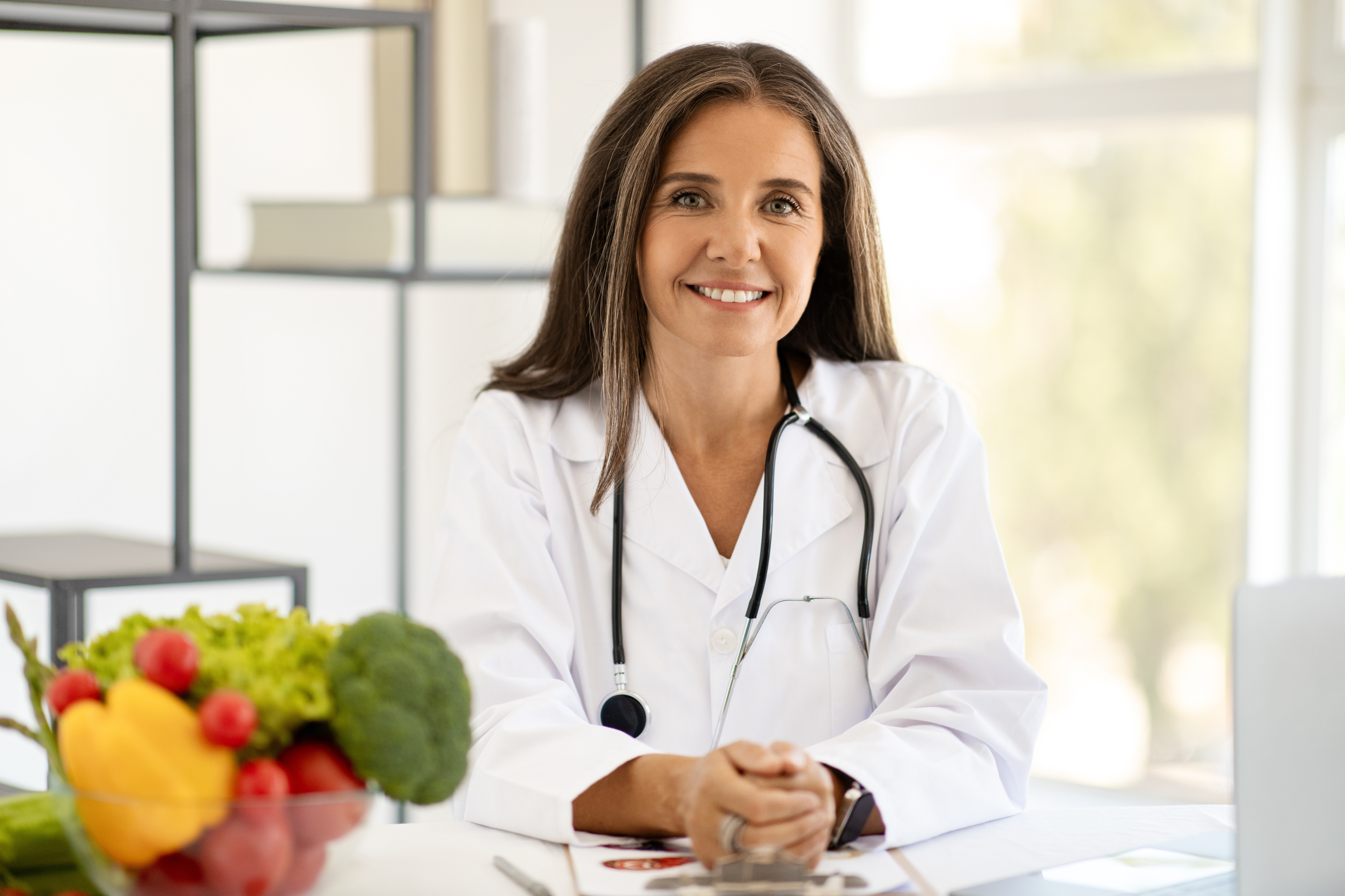 A medical weight loss professional sits behind a desk ready to answer the question “Is medical weight loss worth it for you.
