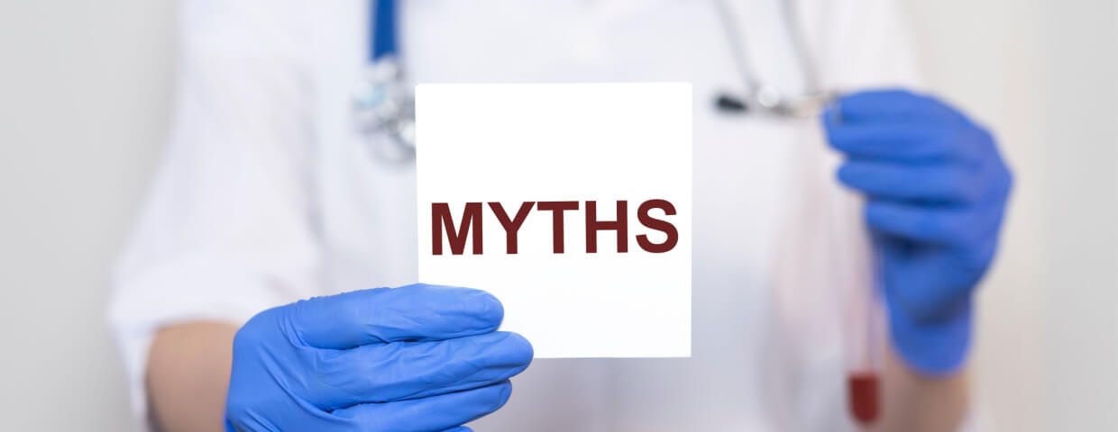gloved doctor holding up sign reading Myths