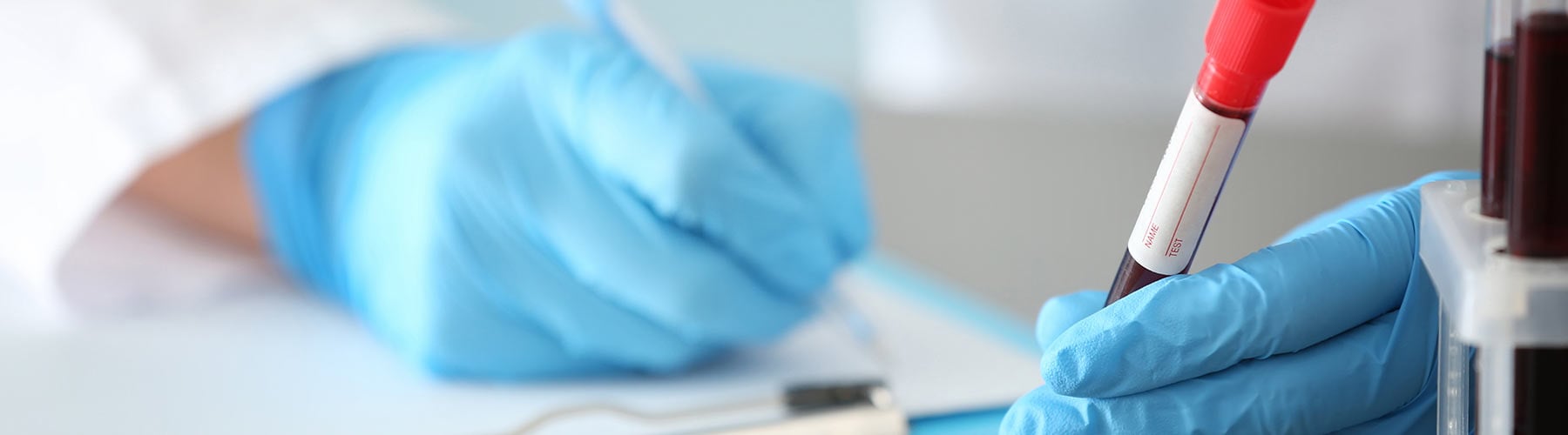 Laboratory assistant with vials of blood