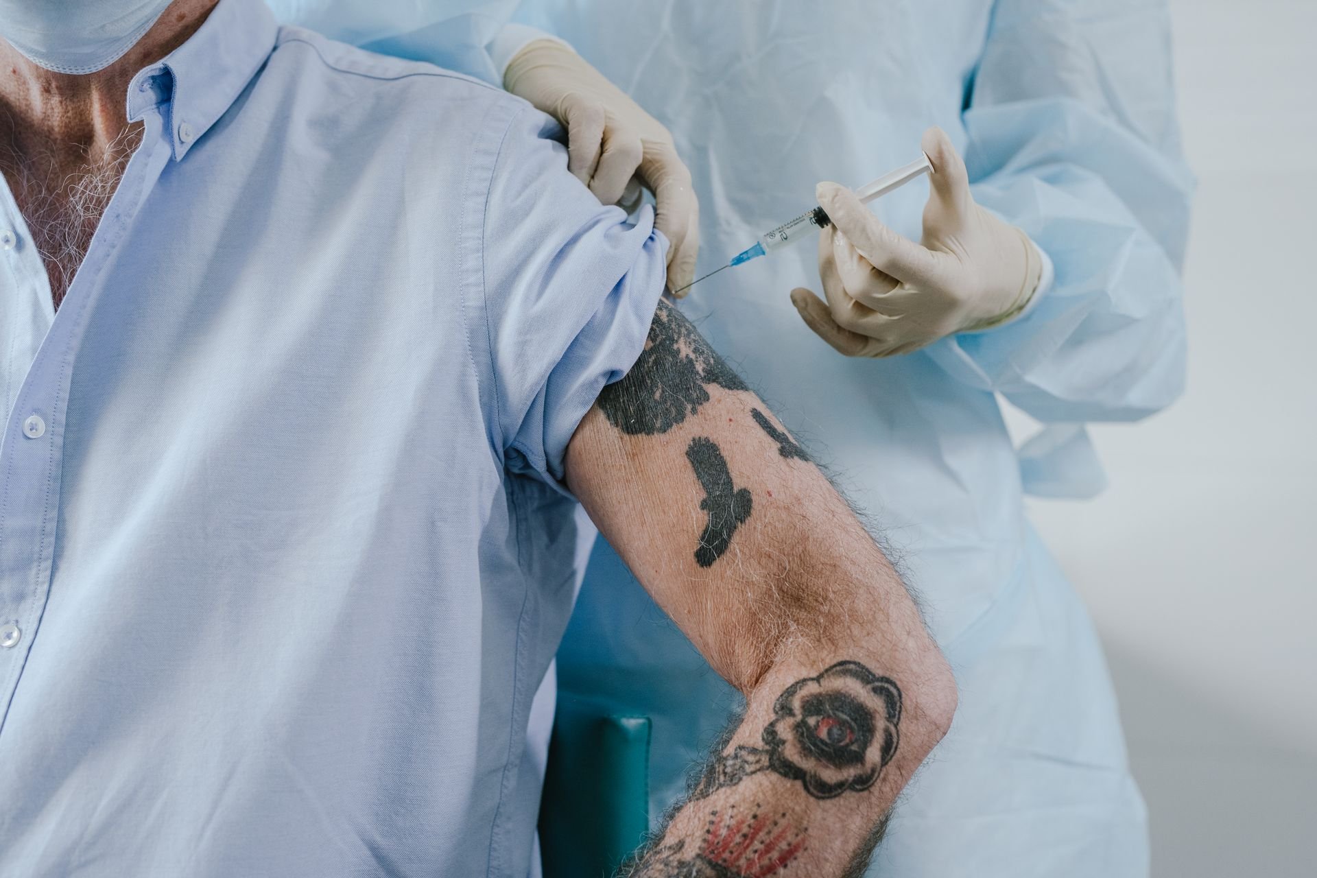 a tattooed man receiving an injection