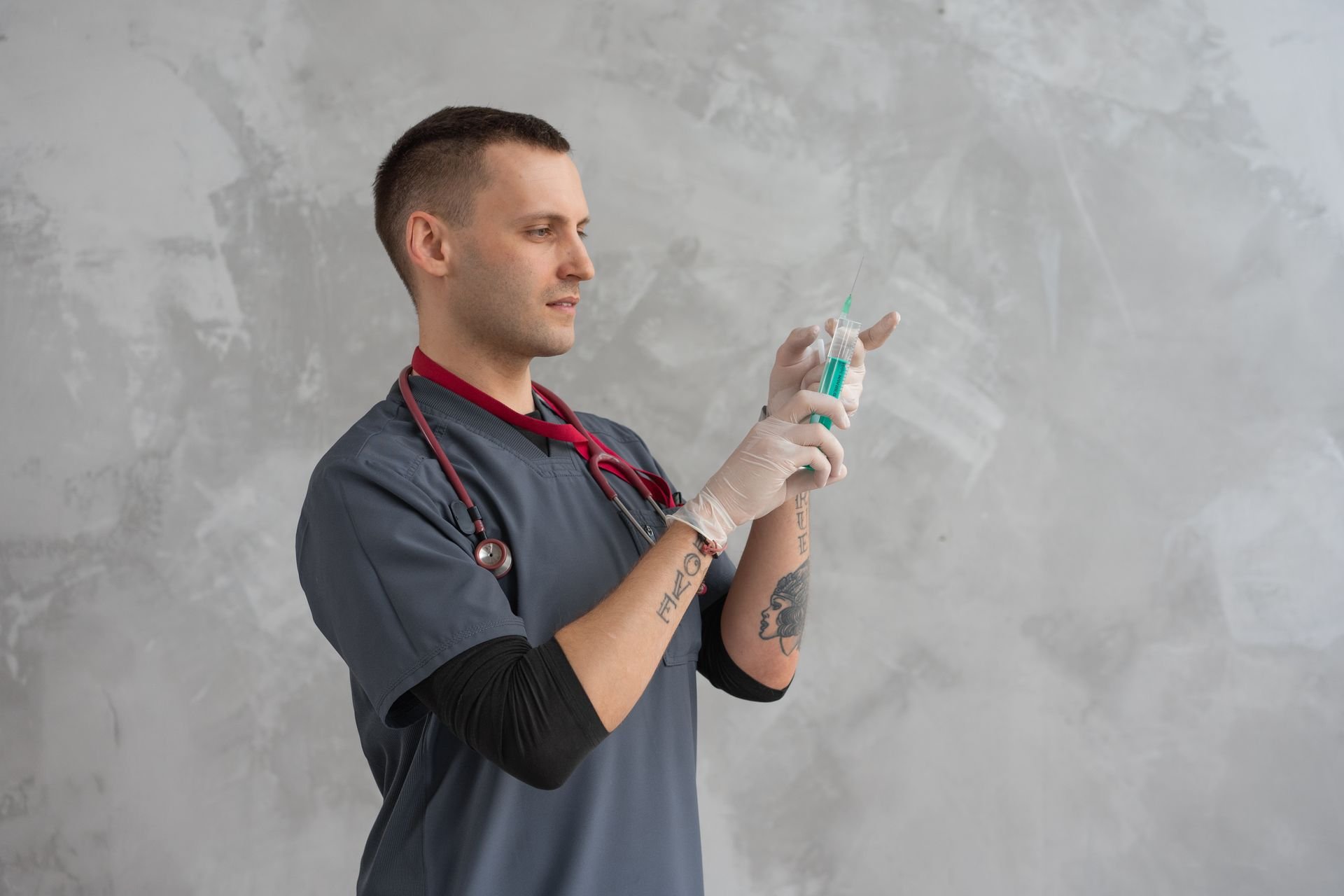 a man in grey scrubs holding a syringe