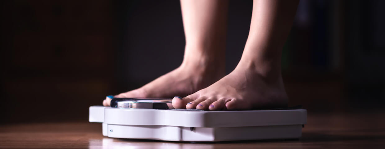 woman on scale measuring her weight