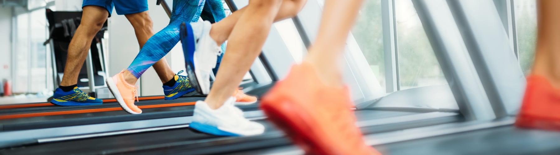 group of people's feet using treadmills at the gym