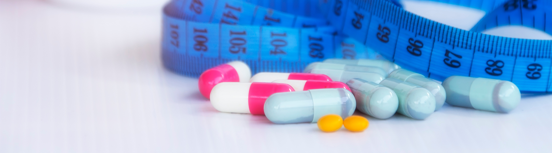 blue measuring tape with colorful pills on table