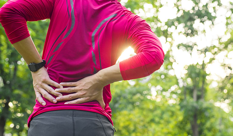 Jogger holding lower back in pain