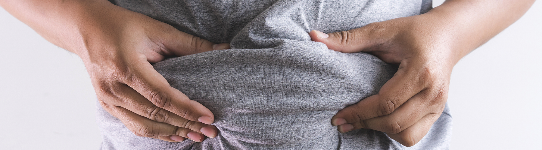man squishes stomach fat, symbolizing weight he'd like to lose
