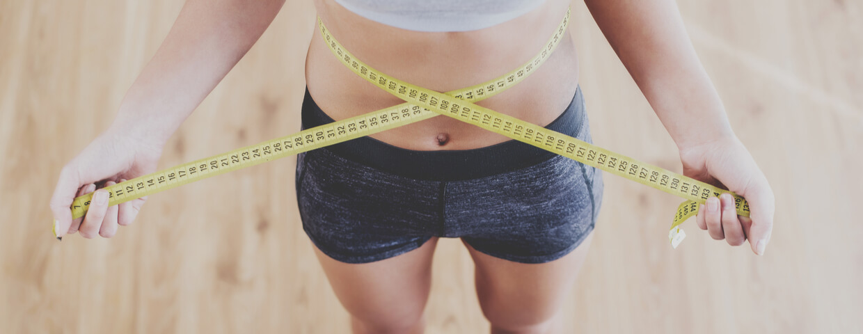 woman measuring waist with tape